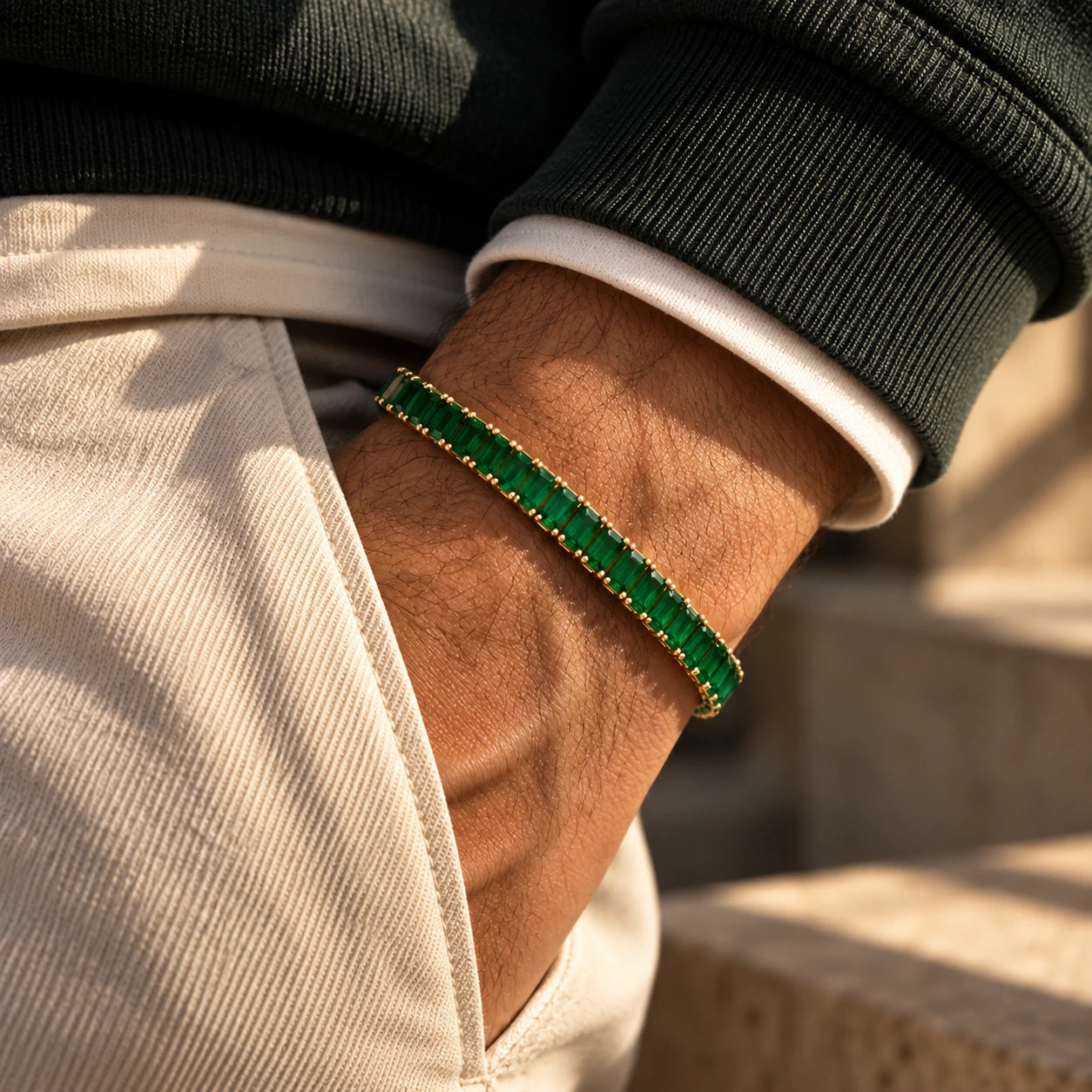 Emerald baguette tennis bracelet in yellow gold, worn on a wrist