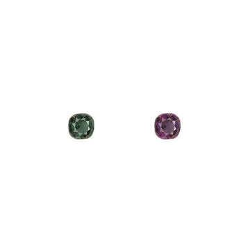 Round alexandrite gemstones, one green and one purple