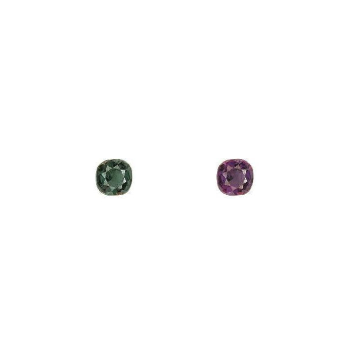 Round alexandrite gemstones, one green and one purple