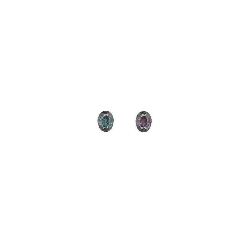 Pair of oval alexandrite gemstones, color-shifting green to reddish purple.