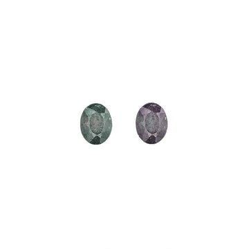 Oval alexandrite gemstones, one green and one purple, faceted for shine