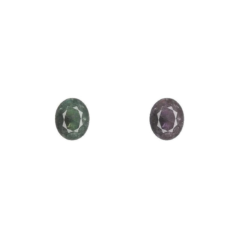 Two oval alexandrite gemstones, faceted, showing green and purple hues