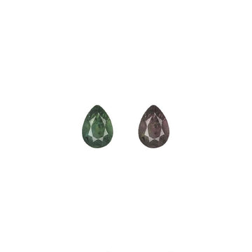 Pear-cut alexandrite gemstones, one green and one purplish-brown, pair