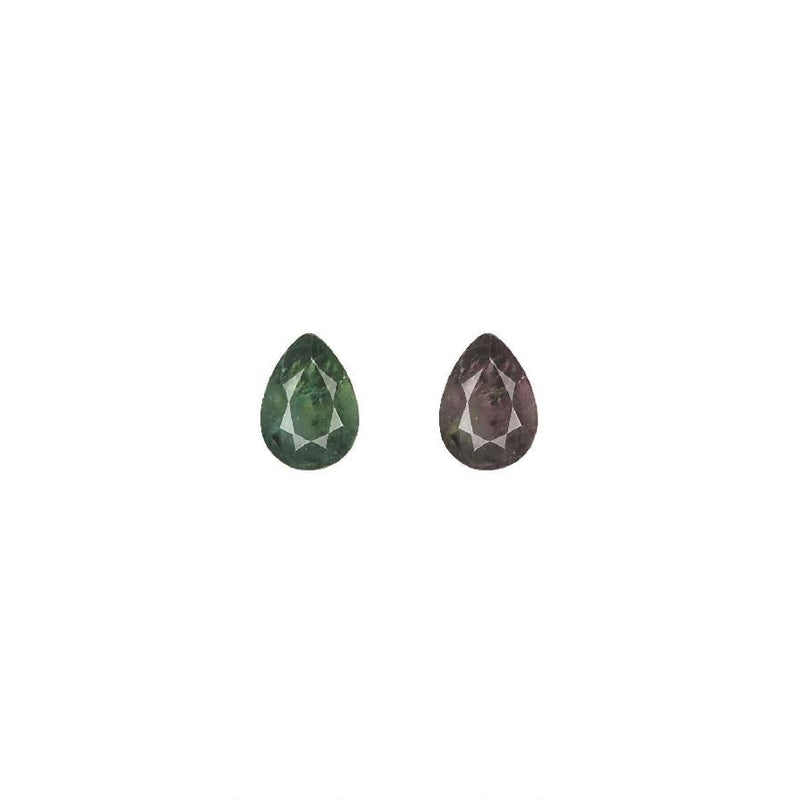 Pear-cut alexandrite gemstones, one green and one purplish-brown, pair