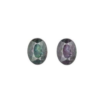 Pair of oval alexandrite gemstones, one blue-green and one purple, faceted