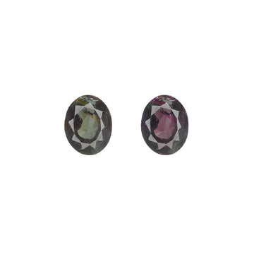Pair of oval alexandrite gemstones, one greenish and one purplish