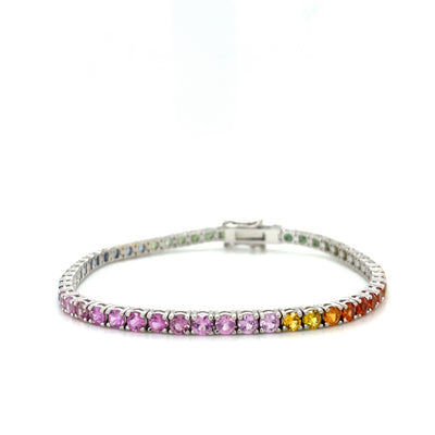 Rainbow ombre sapphire tennis bracelet with clasp at back, white background view.