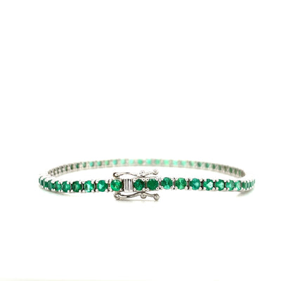 Emerald tennis bracelet with emerald-green round gemstones and a box clasp detail