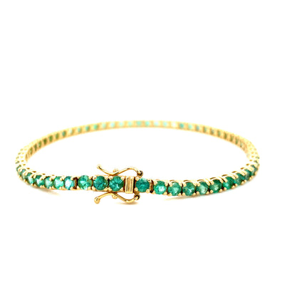 Gold tennis bracelet with round green stones and box clasp with lever