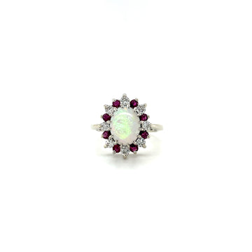 Opal center ring with ruby-red stones and white diamond accents on white gold