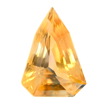 Close-up of a faceted triangular bi-color sapphire with golden and pale tones