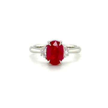 Platinum ring with oval red ruby center and small diamond side stones
