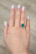 Emerald and diamond ring with green emerald center and slim diamond band