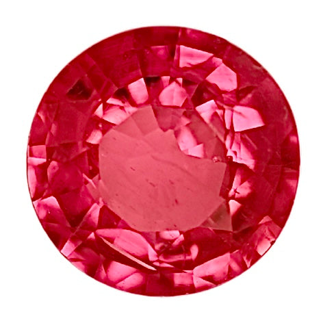 Round red ruby gemstone close-up with faceted crown and pavilion