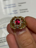 Gold-toned ring with red square ruby center and round clear stones, halo setting