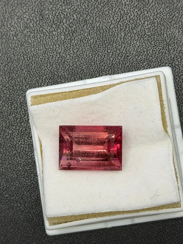 Tourmaline gemstone in rectangular pink cut, set in a white display tray