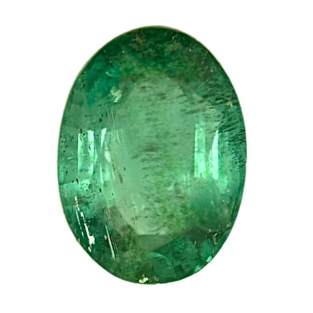 Oval green emerald gemstone, faceted, close-up view.