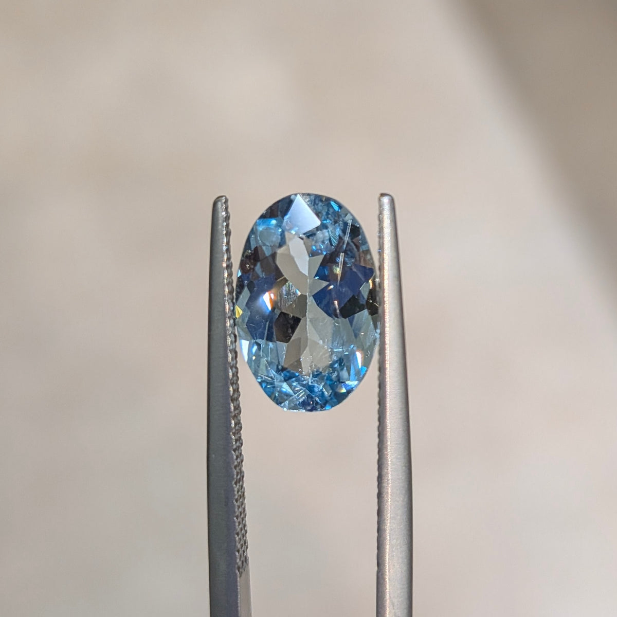 Oval blue aquamarine gemstone in silver prong setting, top view