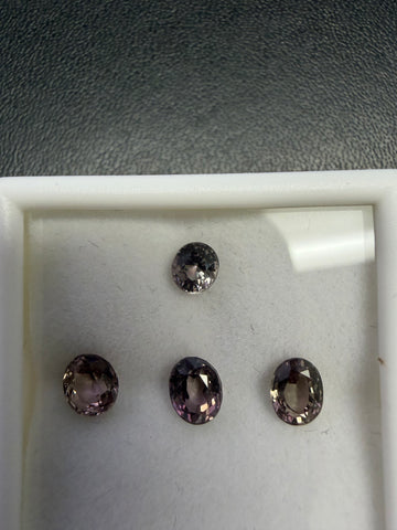 Color-change garnet stones in gift box: one round and three oval dark gems
