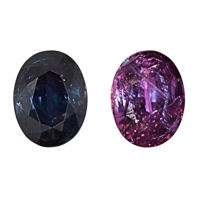 Oval alexandrite gemstone pair, dark blue and vivid purple with faceted surface.