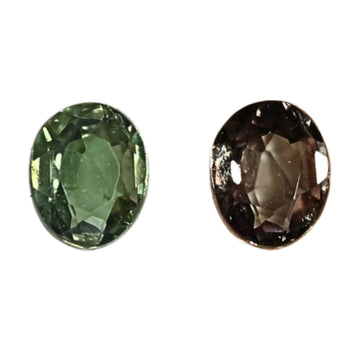 Faceted oval alexandrite gemstones, green and smoky purple, close-up