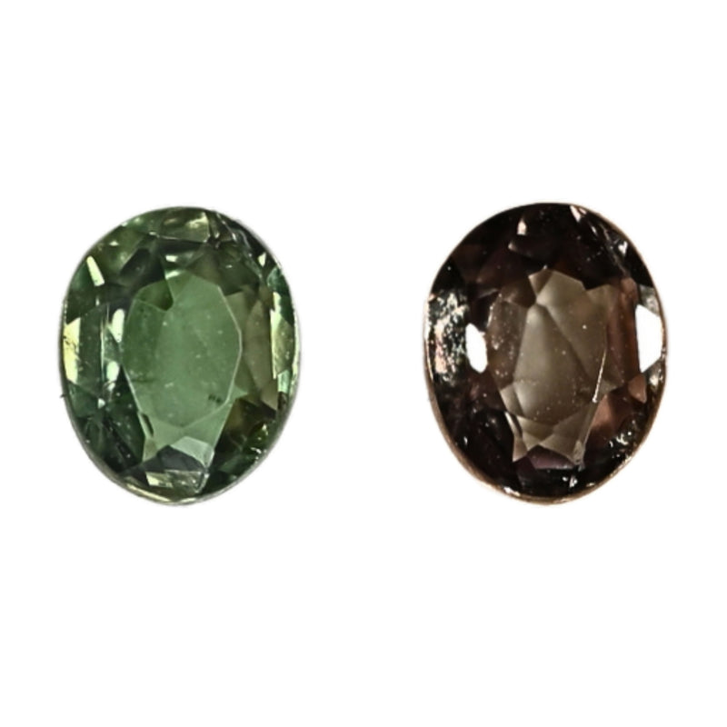 Faceted oval alexandrite gemstones, green and smoky purple, close-up