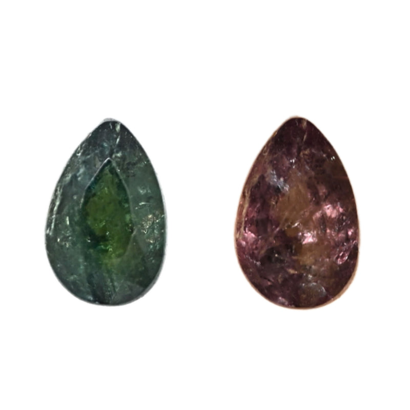 Oval alexandrite gemstones, one green and one purple, close-up view