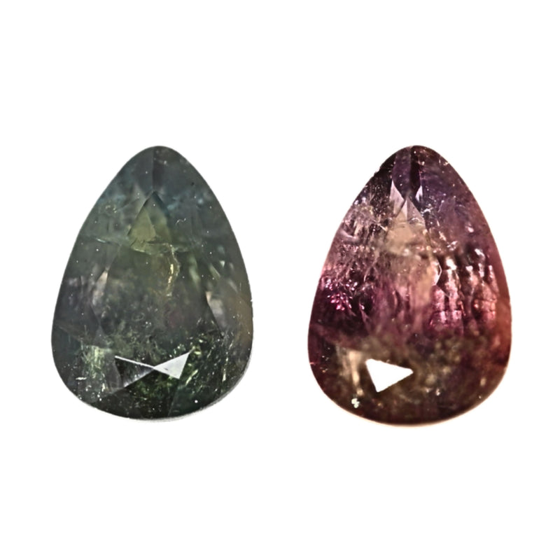 Pear-shaped gemstones, one green and one purple, polished facets close-up