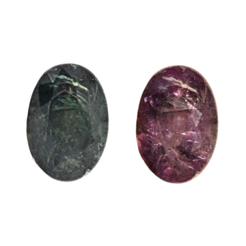 Two oval alexandrite gemstones with faceted surfaces: dark green and deep purple.