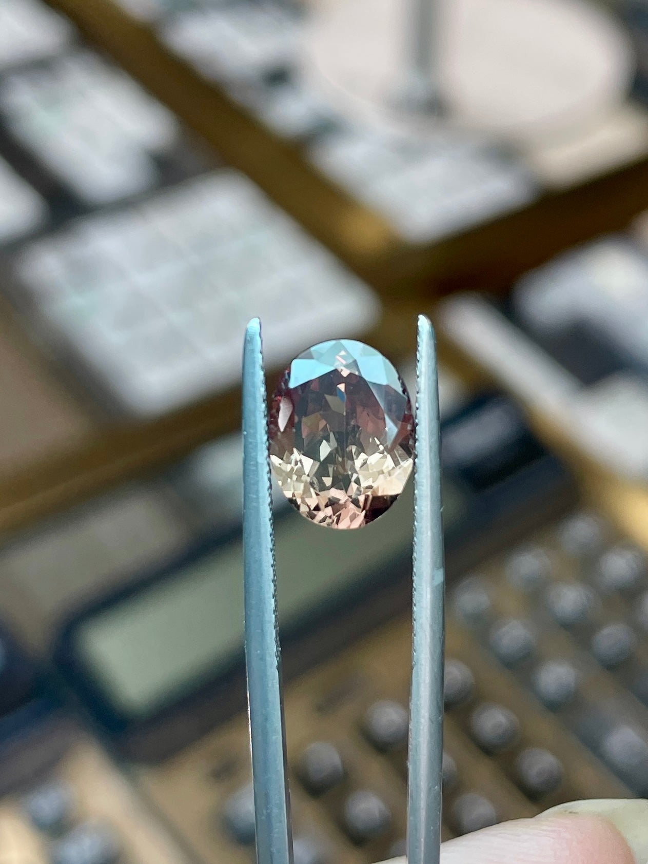 Faceted oval color-change garnet gemstone between metal prongs