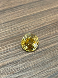 Round yellow zircon gemstone on wood surface