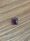 2.45ct purple cushion-cut spinel gemstone on wood surface