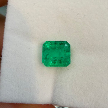 Emerald-cut green gemstone with step facets, rectangular shape