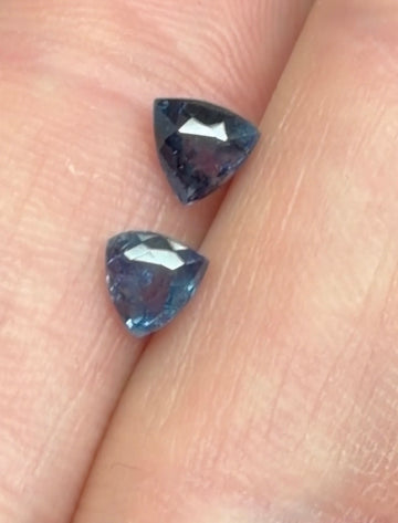 Pair of faceted triangular alexandrite gemstones, dark blue with color shift