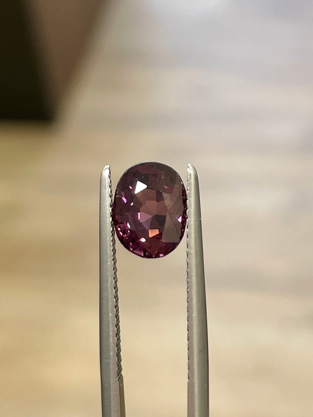 Oval maroon-purple spinel gemstone in open prong setting with metal rails