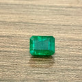 Emerald-cut green gemstone with rectangular step facets, loose