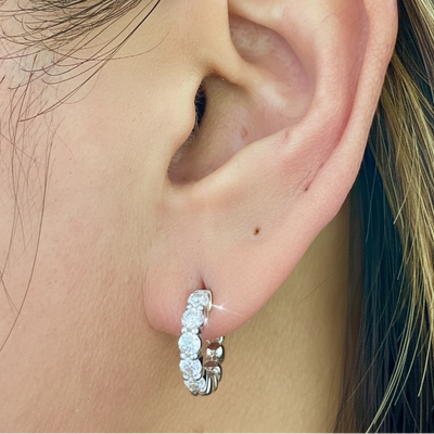 Diamond mini hoop earrings on ear, hoop with pave diamonds and small sparkle details.
