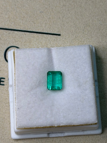 Green emerald gemstone in square cut, set in a display box