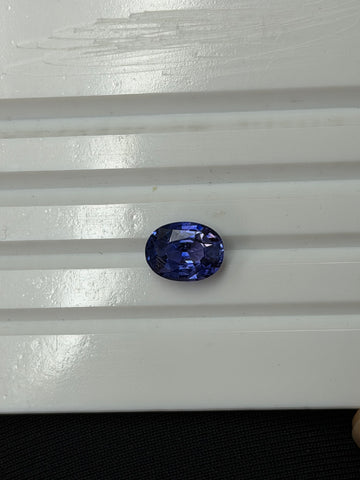 Faceted oval sapphire gemstone, deep blue-purple