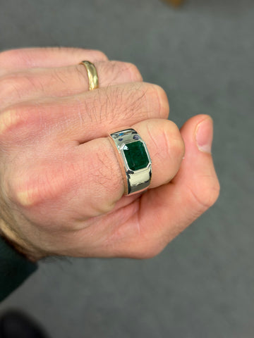 Silver ring with square green gemstone and polished bezel, worn on hand