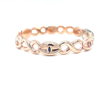 Rose gold bracelet with blue sapphire eyelet motifs and interlinked oval loops.