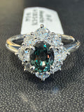 Alexandrite halo ring with deep green oval center and diamond-accented halo