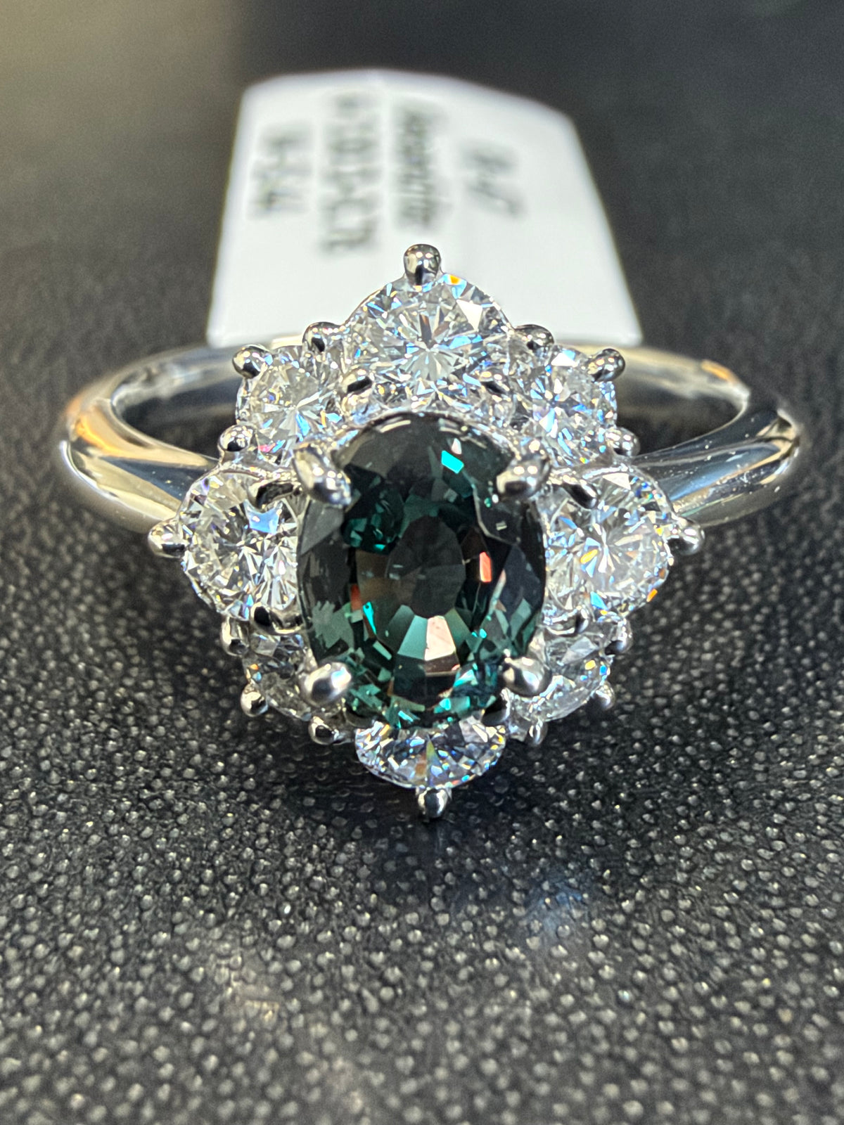 Alexandrite halo ring with deep green oval center and diamond-accented halo
