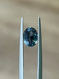 Light-blue oval sapphire gemstone held by two metal prongs
