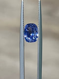 Blue sapphire gemstone in metal prong setting, close-up