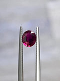 Oval ruby gemstone in silver prongs setting, bright red