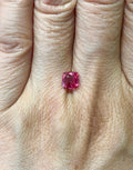 Small cushion-cut Mahenge spinel shown on a hand for scale