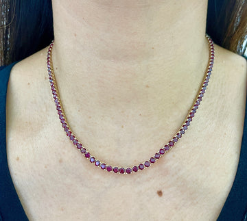Ruby tennis necklace with small round faceted red gemstones in a linked line