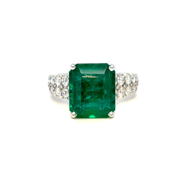 18k white gold ring with square emerald-cut green center and side diamond clusters