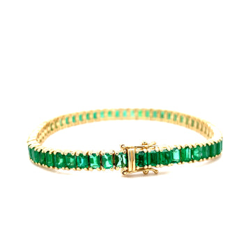 Emerald tennis bracelet with emerald-cut green gemstones in yellow gold bezel